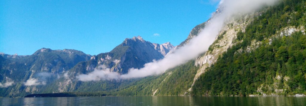 Foto Bergkette mit Wolken in den Hängen. Was ist meine wahre Größe angesichts solcher Panoramen? Was sehe ich und was macht das mit mir? Kann ich das auch beschreiben und dadurch meinen Sinn für das Schöne, aber auch für mich schärfen?