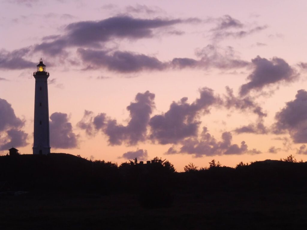 Foto Leuchttrum vor ornage-violettem Abendhimmel