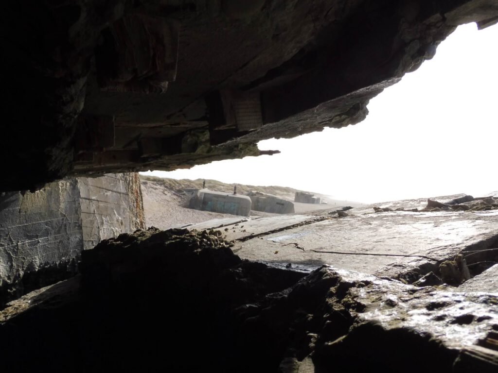 Aus einem Gefechtsbunker heraus andere Bunker am Strand fotografiert.