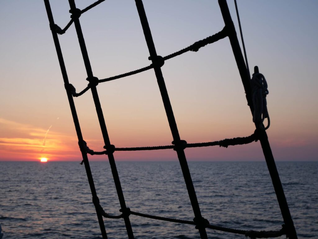 Auf der Nordsee an Bord der Großherzogin Elisabeth. Blick auf den Sonnenaufgang durch die Wanten des Großsegels. Weiter oben in fanden die Vater-Tochter-Glücksmomente statt.