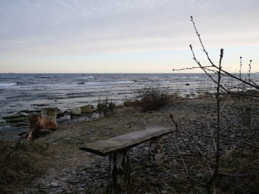 Das Meer ist ein Kraftort: Eine Holzbank direkt am Meer lädt zum sitzen und verweilen ein.